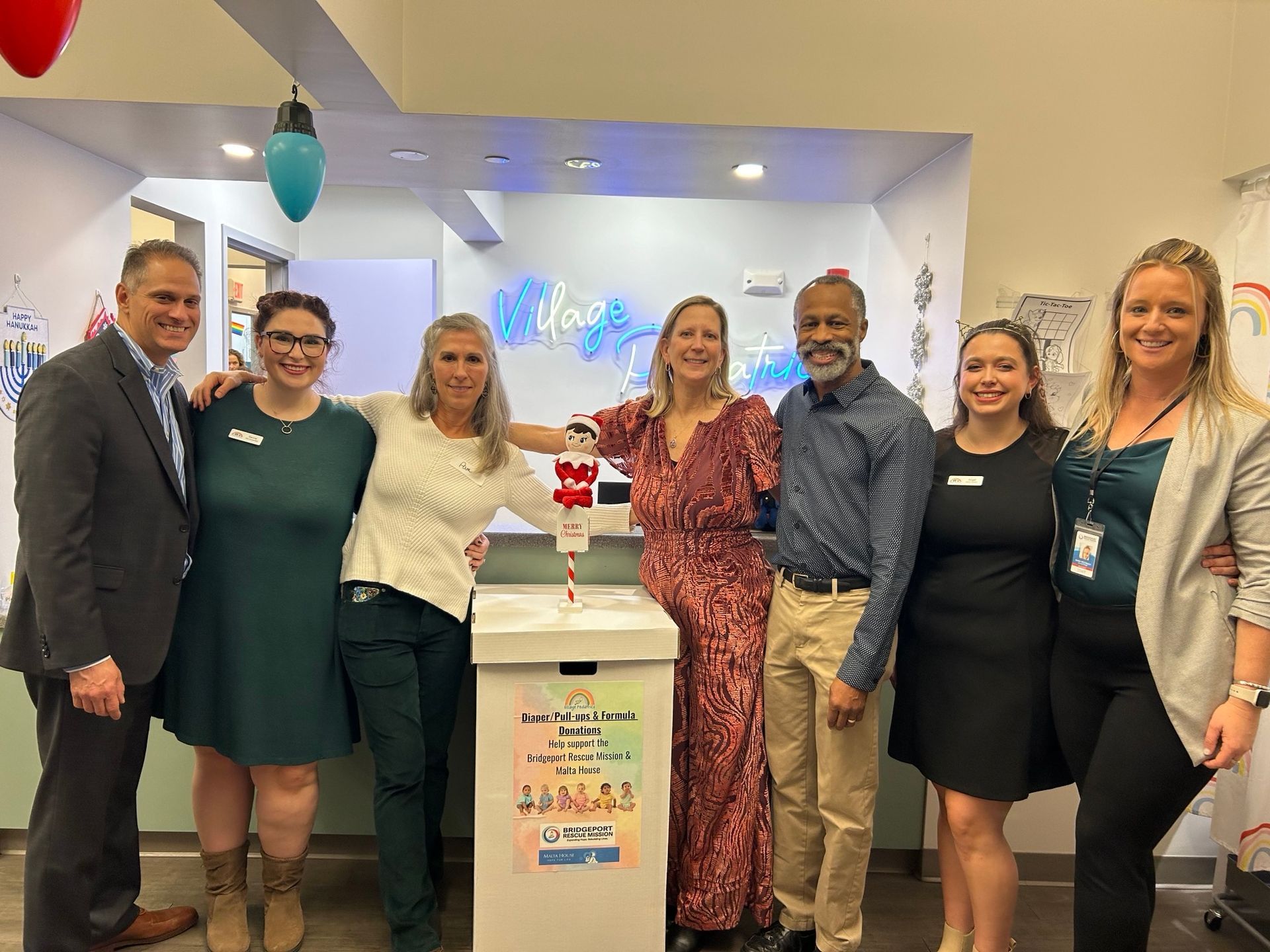 A group of people are standing next to each other in front of a box.