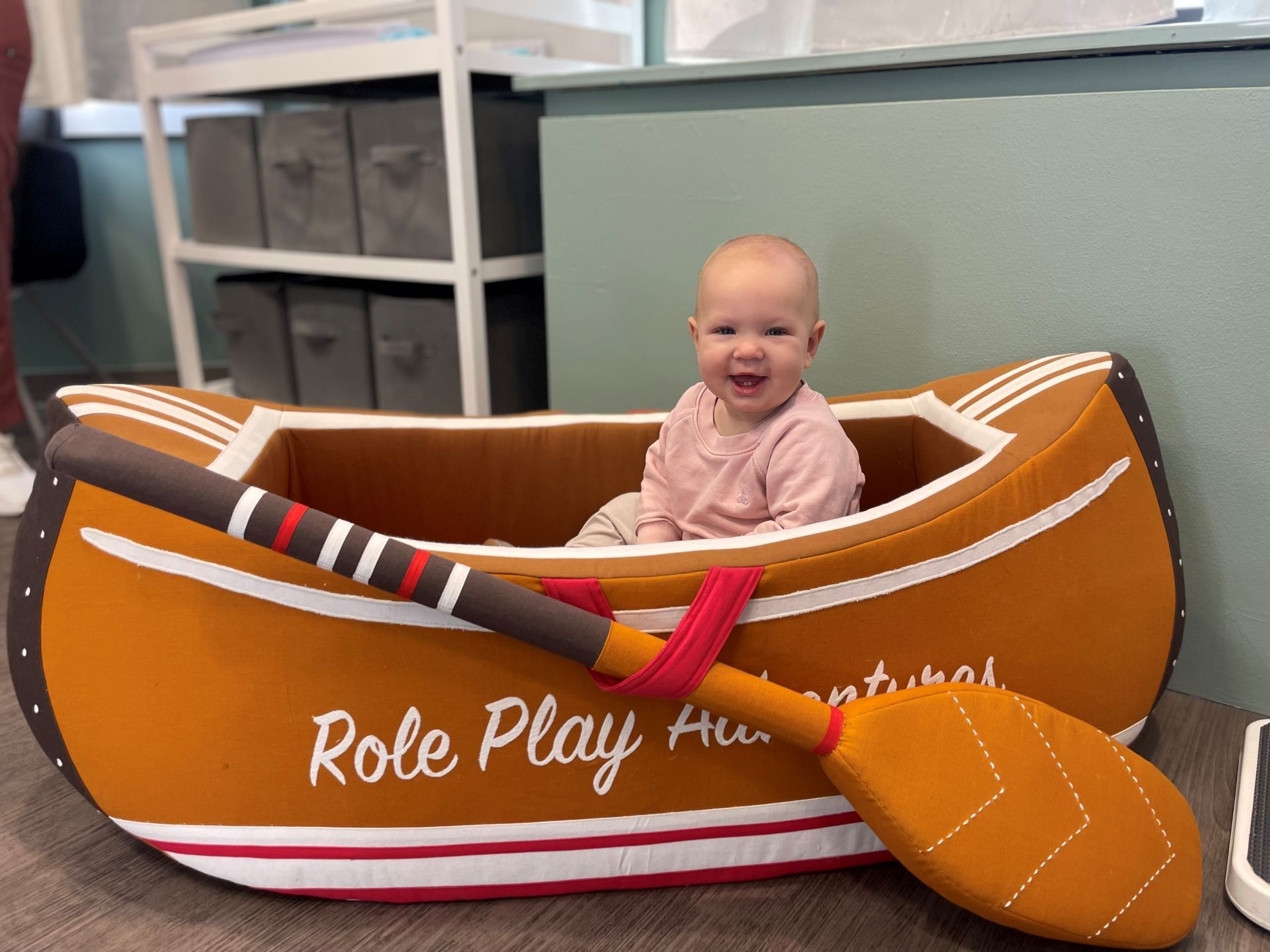 Smiling baby sitting in a toy boat