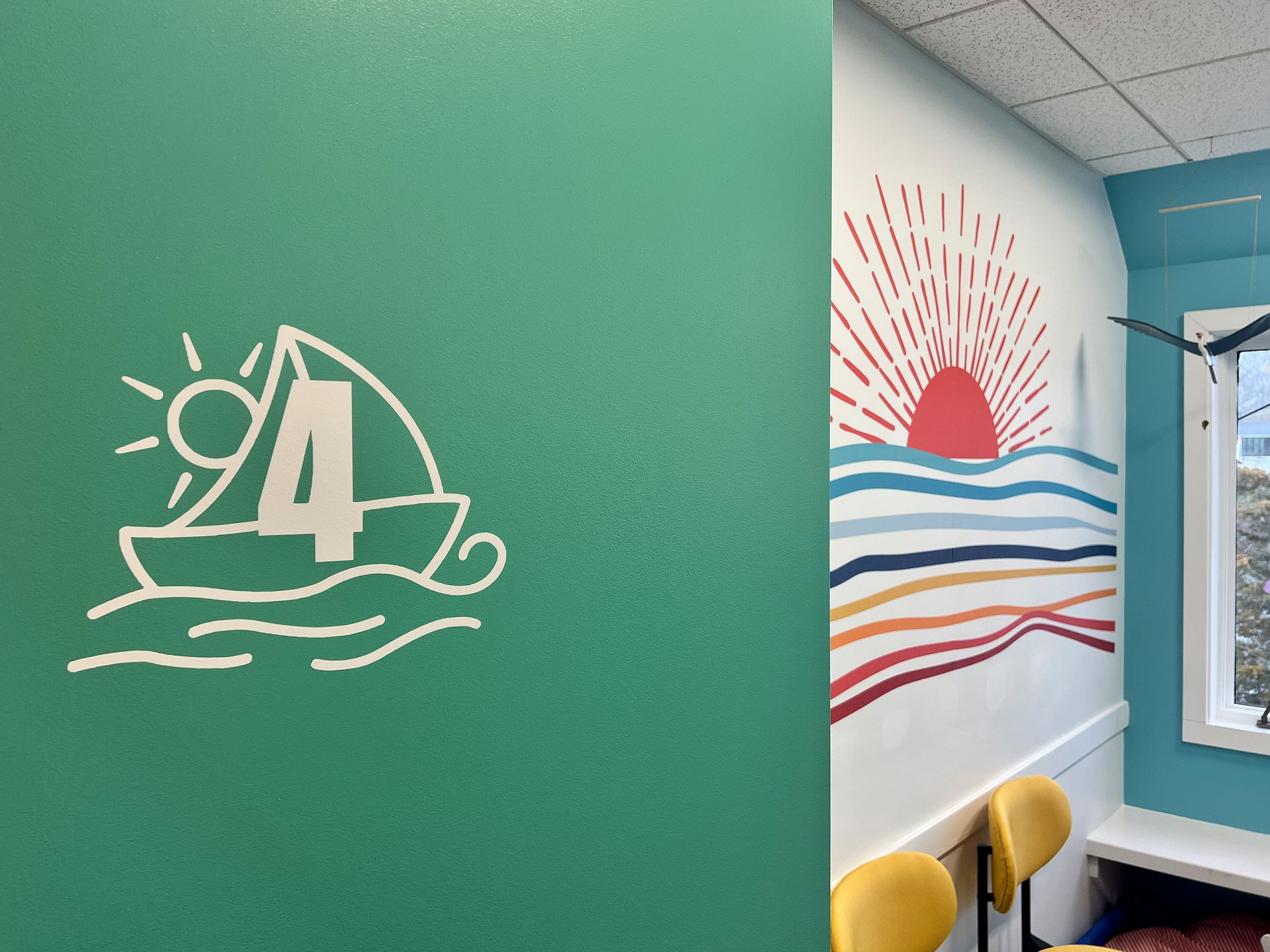 A green wall with a boat and the number four on it