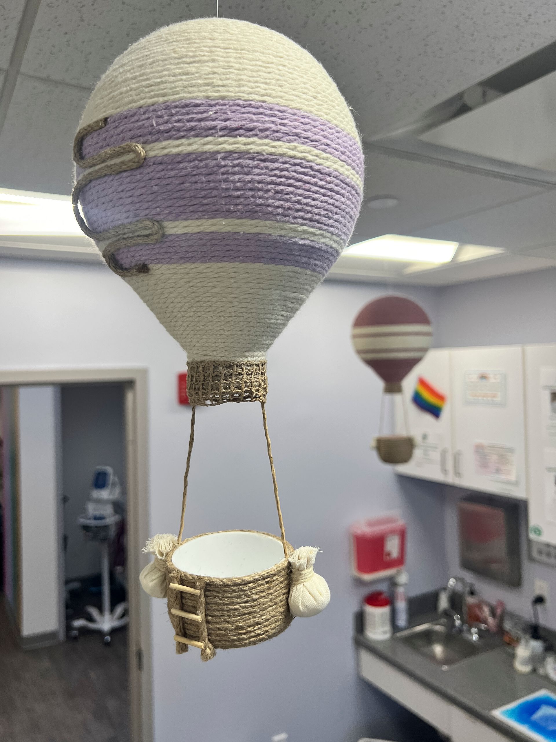 A purple and white hot air balloon hanging from the ceiling
