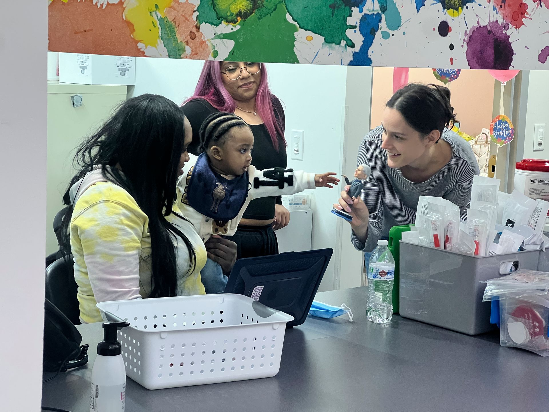 Office staff at village pediatrics greeting a small child