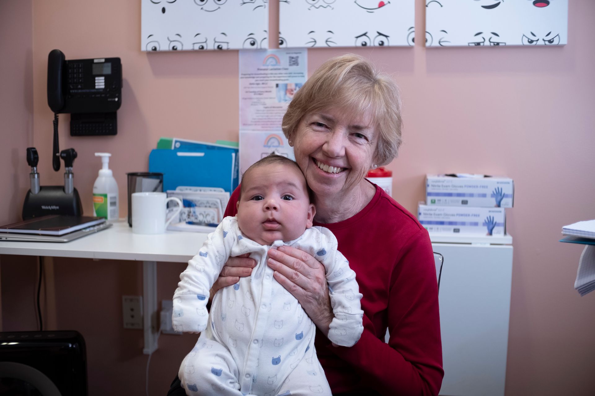 Newborn care Westport, CT Smiling pediatrician holding a newborn baby in Westport, CT.