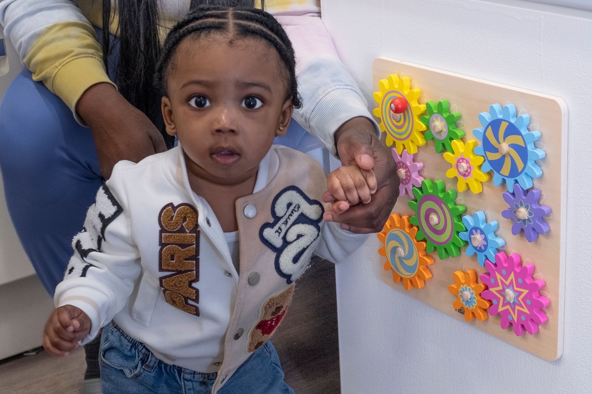 A little girl wearing a jacket with the word paris on it