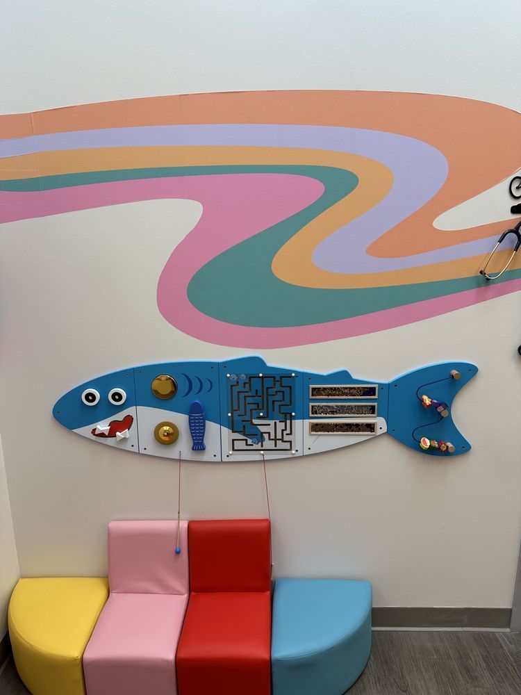 A wall with a fish and a rainbow painted on it