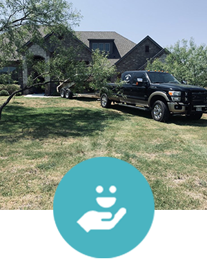 A black truck is parked in front of a large house.