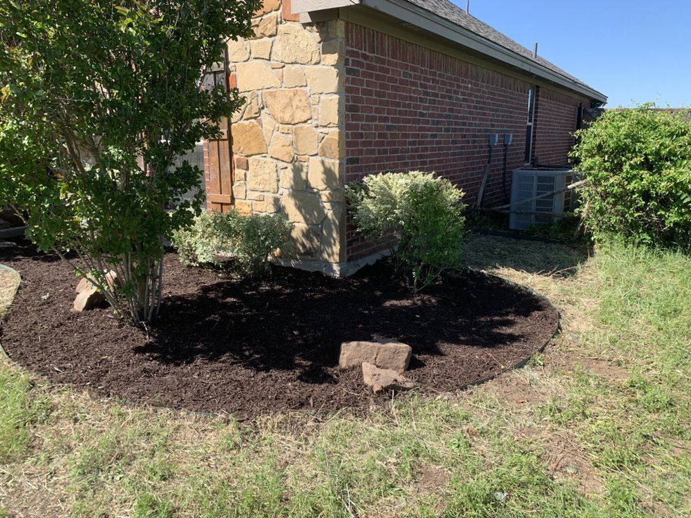 A brick house with a lush green yard in front of it.