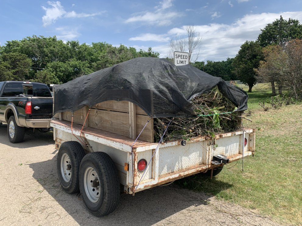 A trailer is sitting on the side of the road next to a truck.