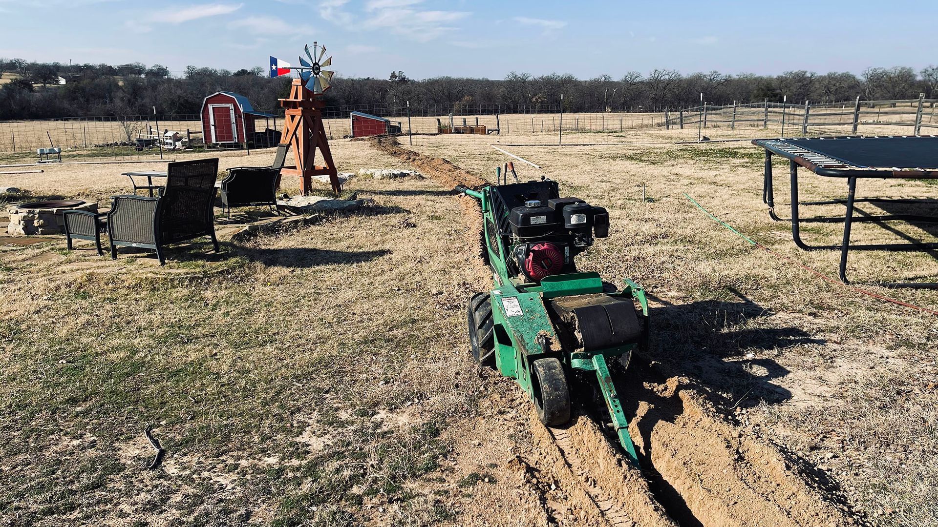 A green tractor is sitting in the middle of a field.