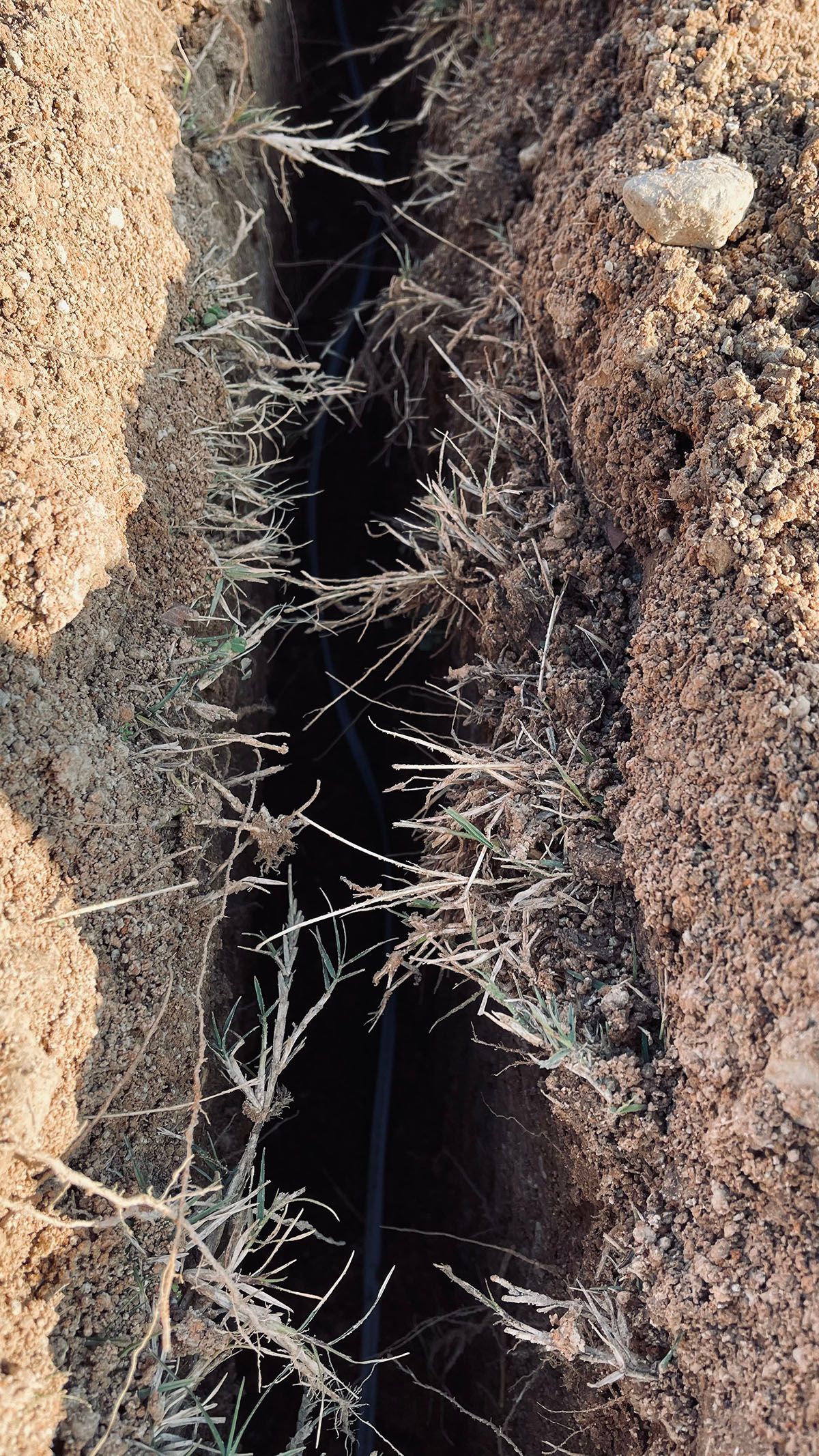 A close up of a hole in the ground with a hose coming out of it.