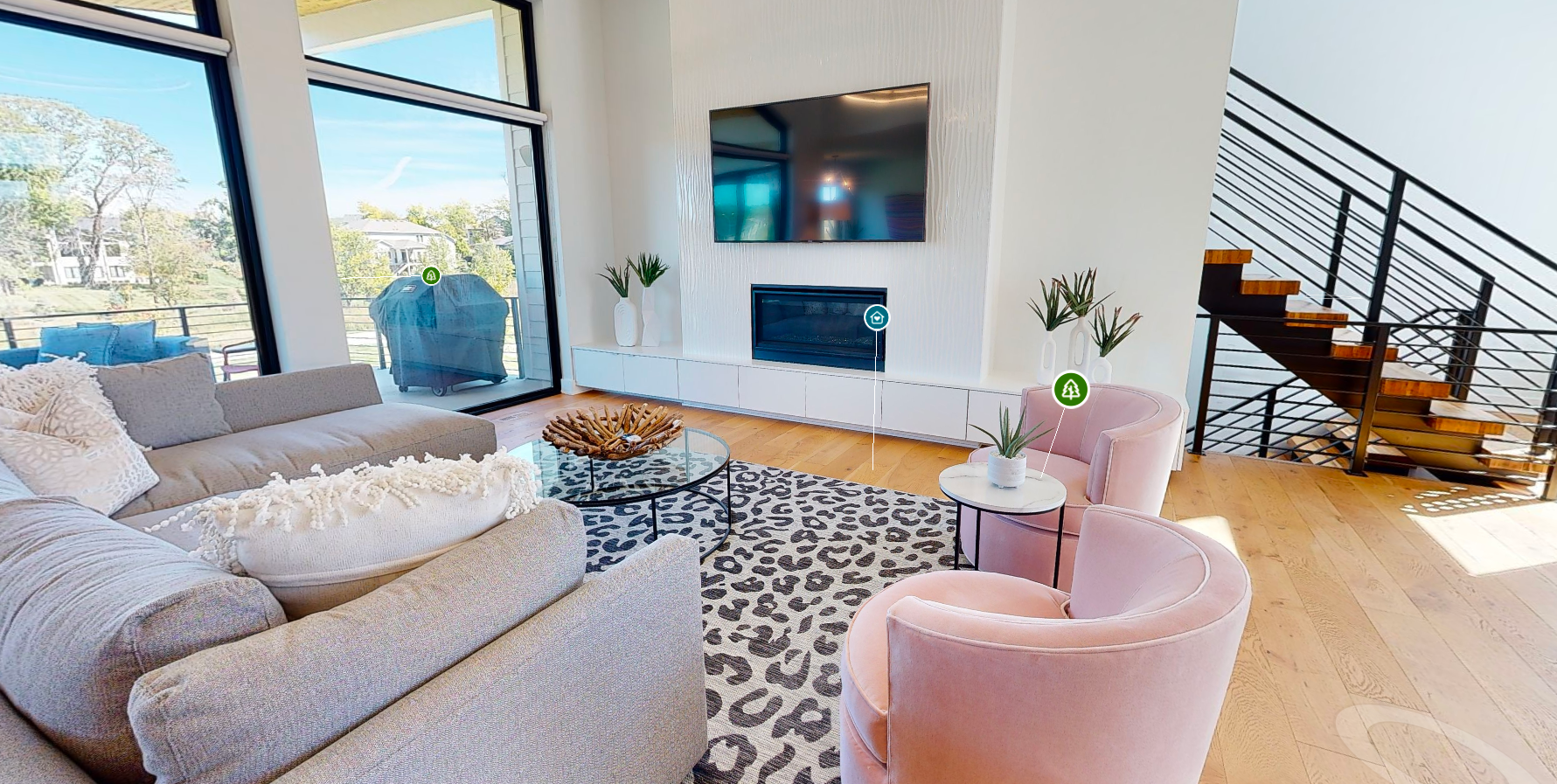 A living room with a couch , chairs , and a flat screen tv.