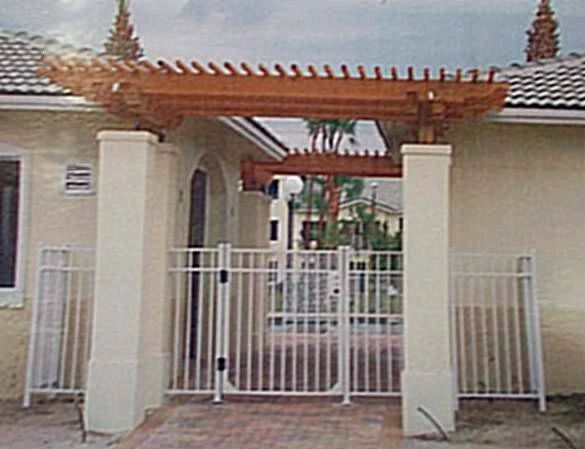 A white house with a wooden pergola and a gate