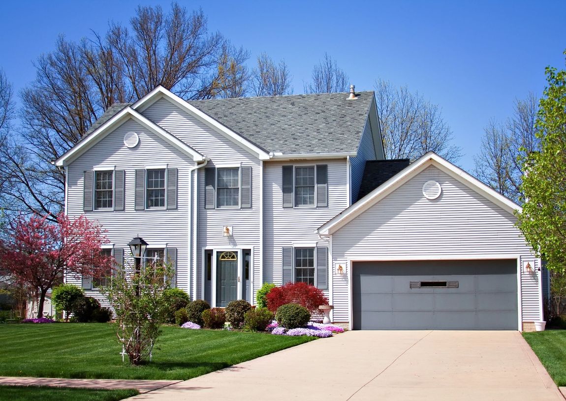 two story house with white siding and manicured lawn