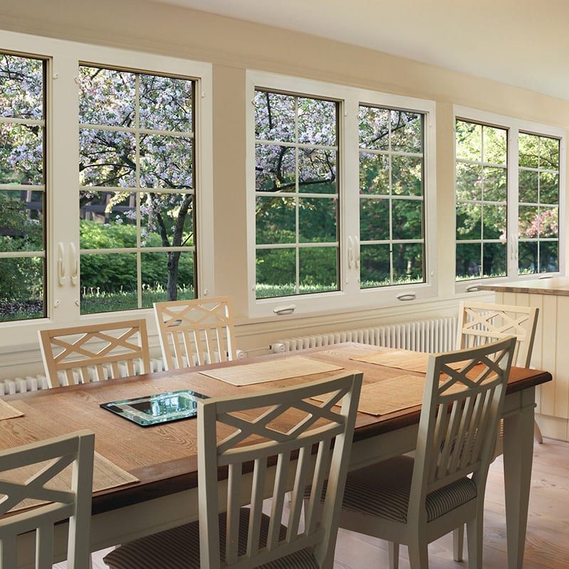 dining room with table, chairs, and several exterior windows in the background