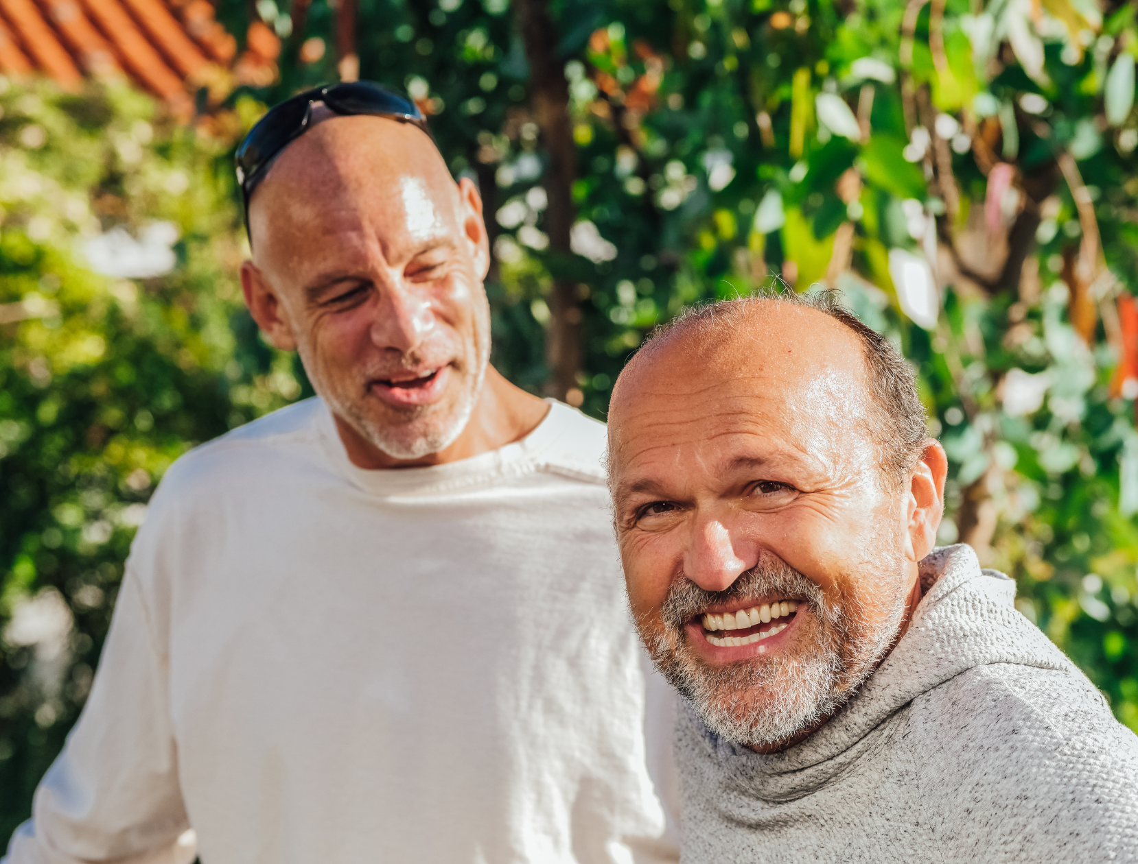 Two men are standing next to each other and smiling for the camera.