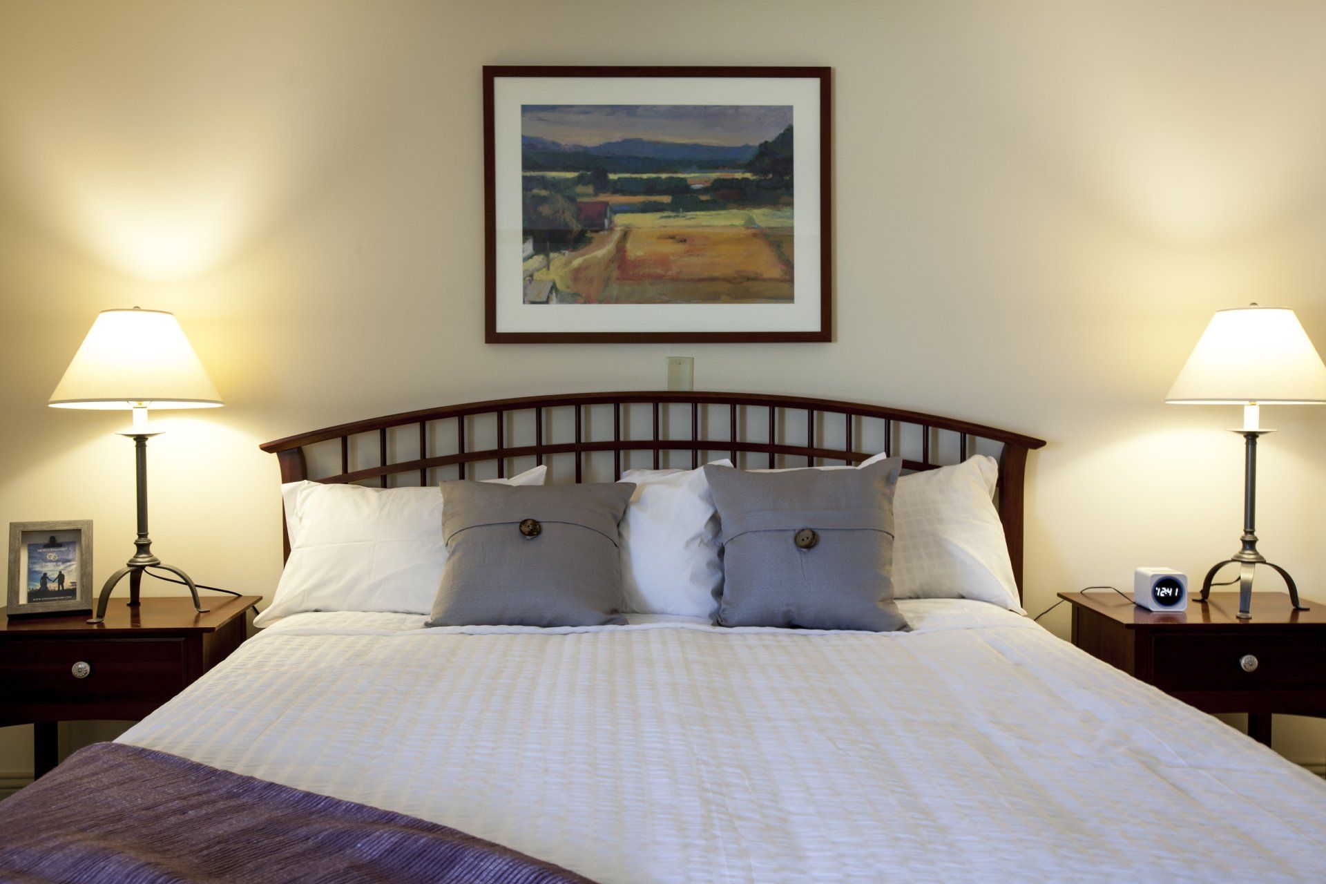 The Lilac Room features a soft king size bed, gray throw pillows and  a soft lilac colored throw blanket