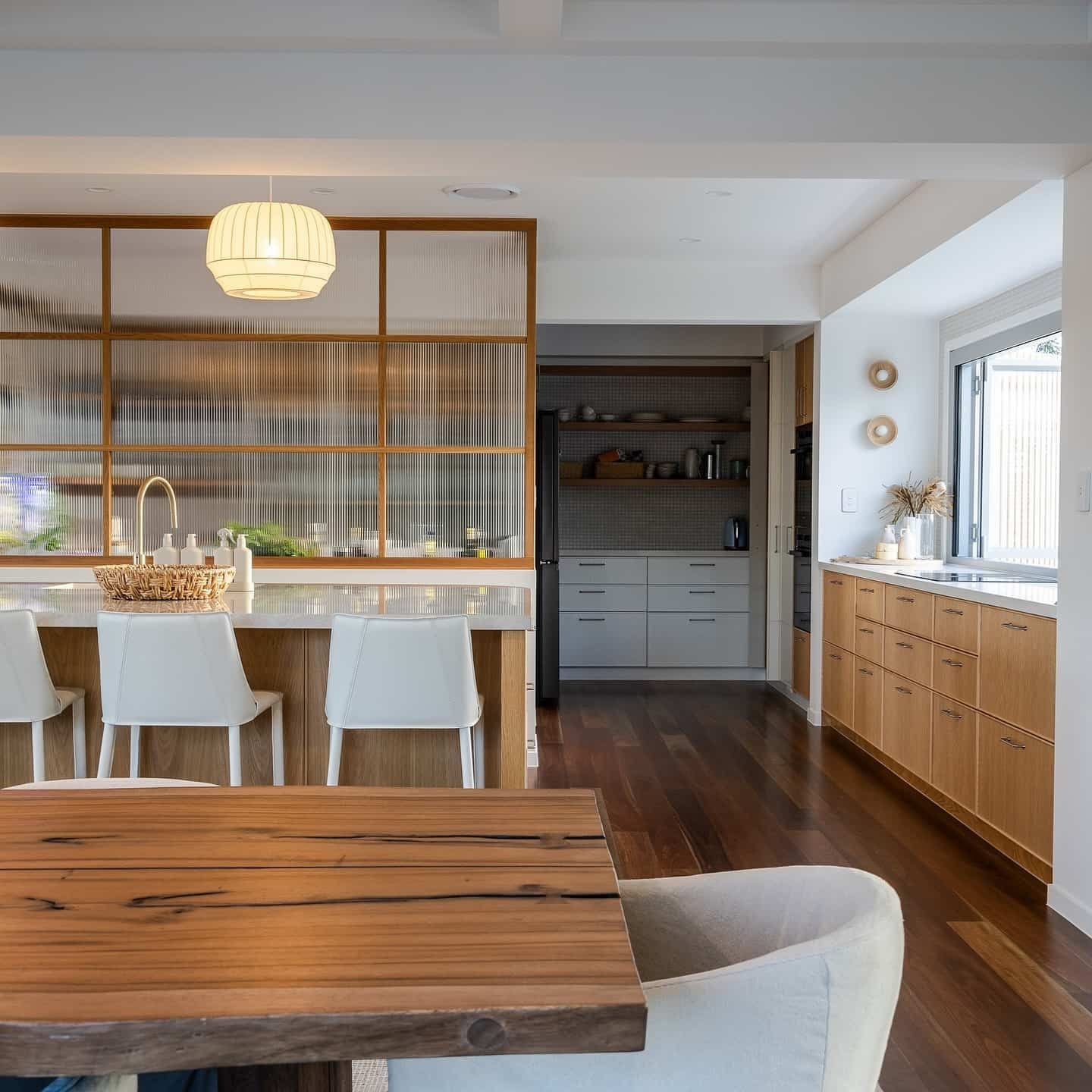 A Kitchen With a Wooden Table and White Chairs — JIC Projects Pty Ltd in Runaway Bay, QLD