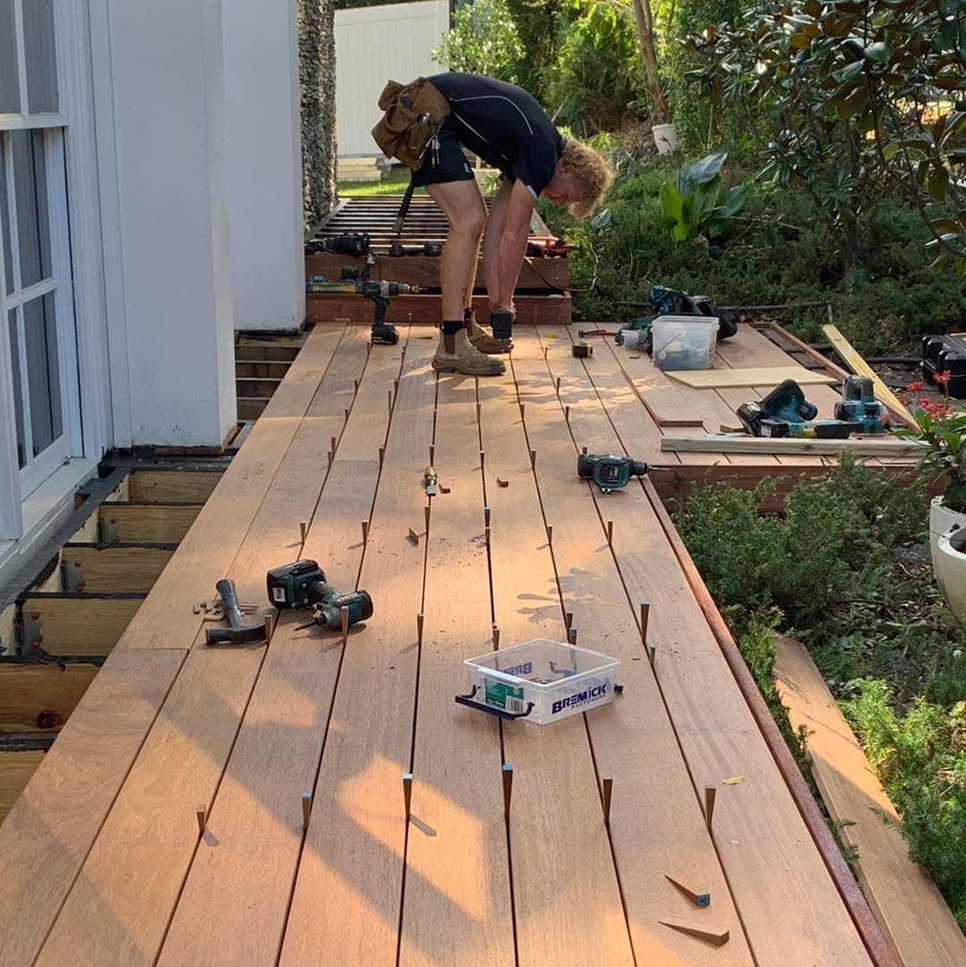 A Man is Working on a Wooden Deck — JIC Projects Pty Ltd in Runaway Bay, QLD