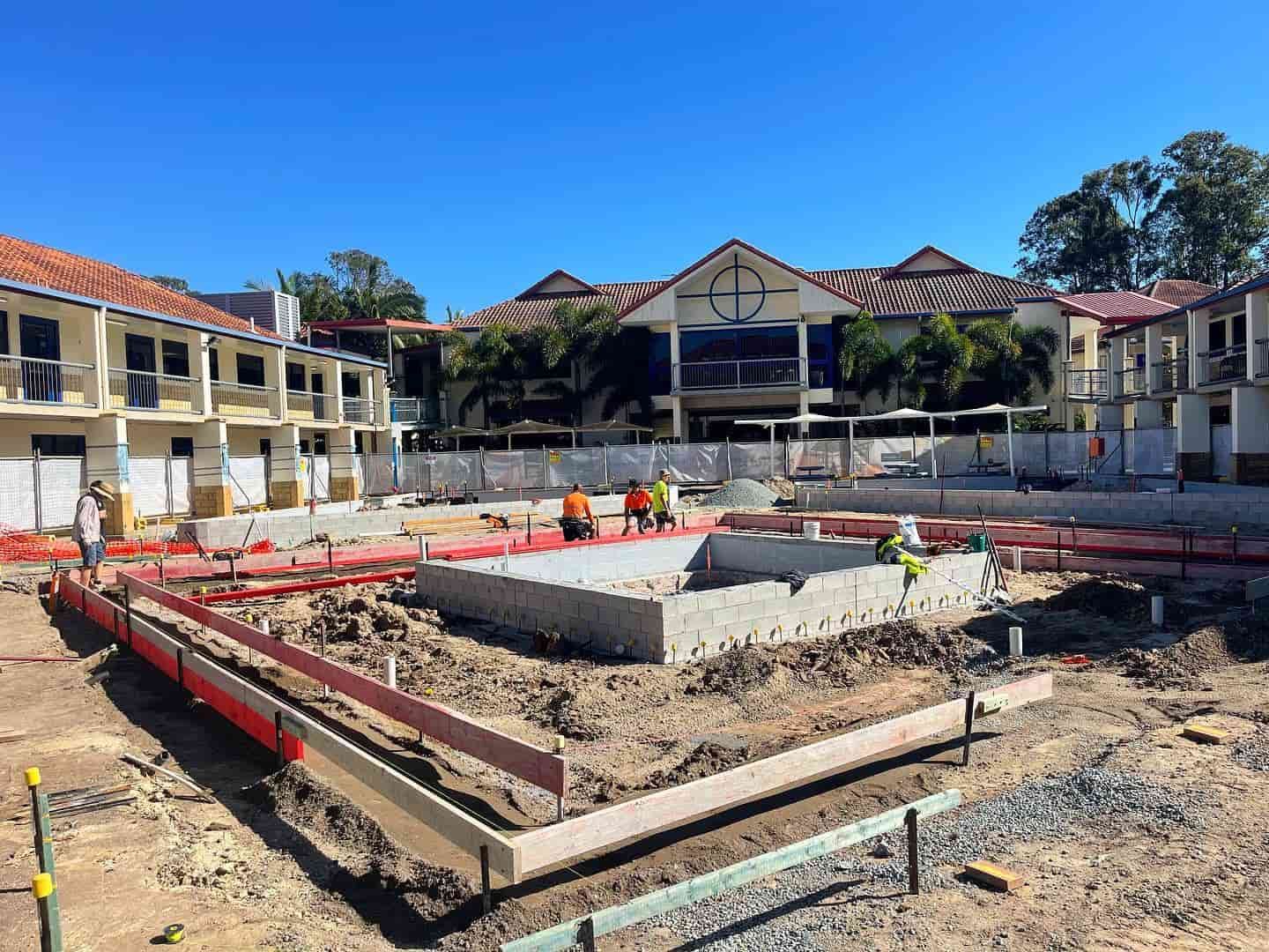 A Construction Site With a Large Building in the Background — JIC Projects Pty Ltd in Runaway Bay, QLD
