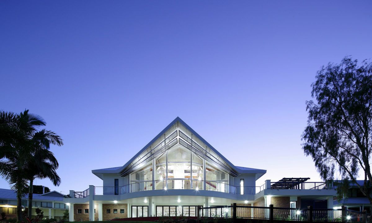 A green and white building with a blue sky in the background