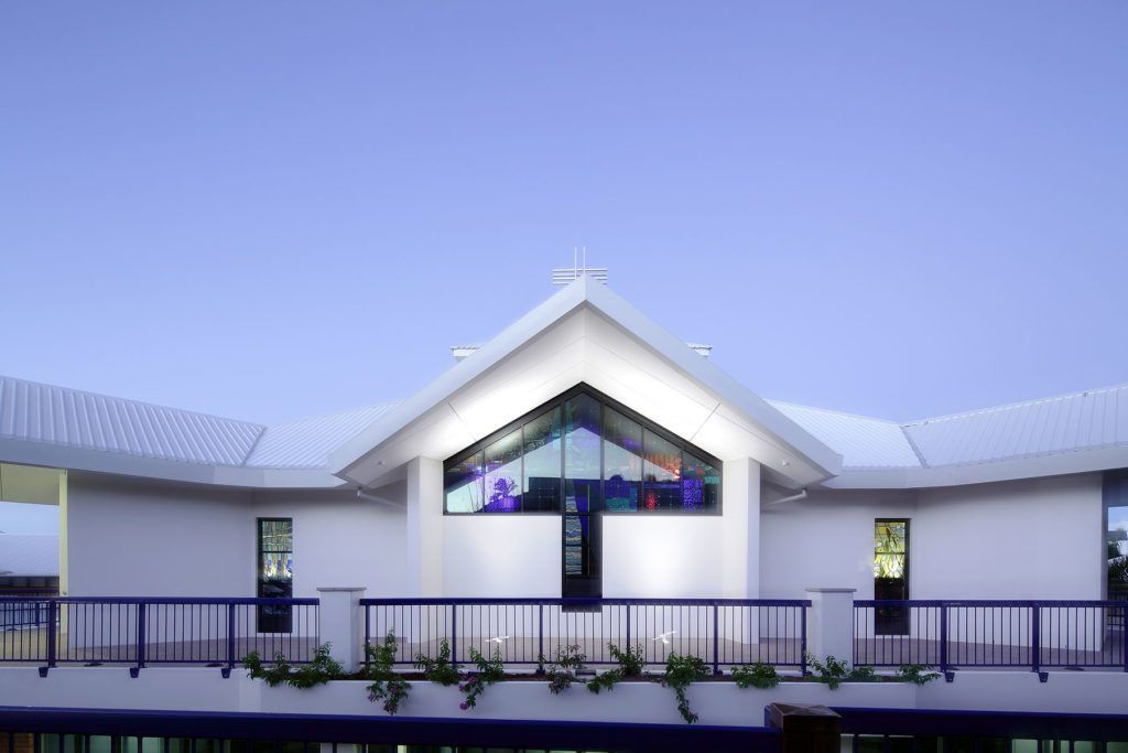 A White Building With a Stained Glass Window and a Balcony — JIC Projects Pty Ltd in Runaway Bay, QLD