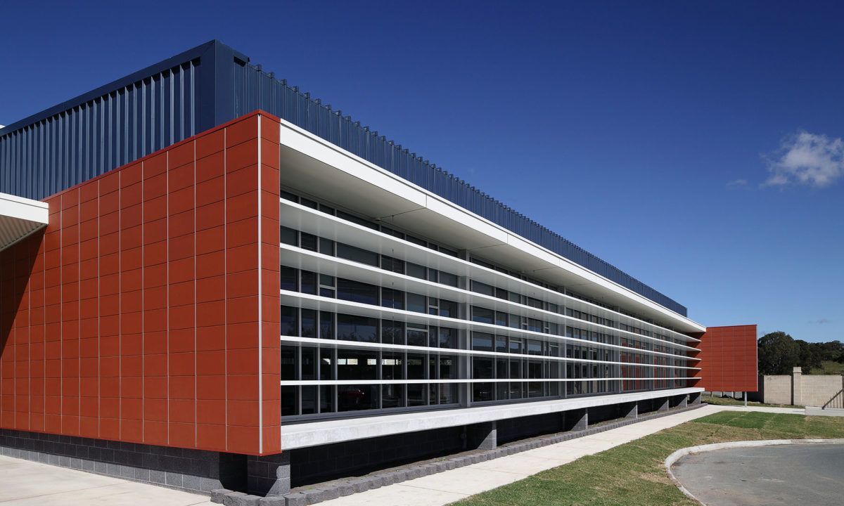 A green and white building with a blue sky in the background