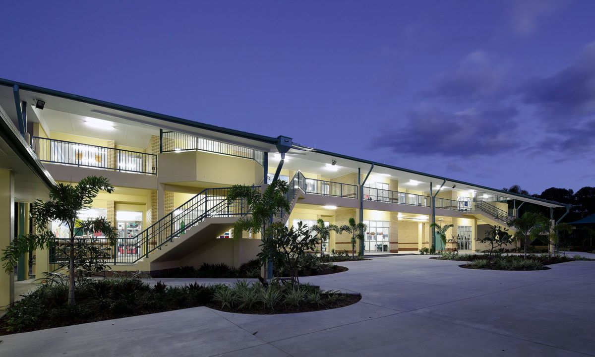 A green and white building with a blue sky in the background