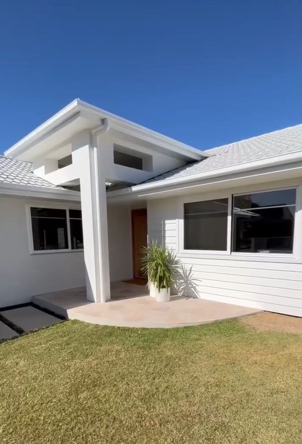 A White House With a Lot of Windows and a Blue Sky in the Background — JIC Projects Pty Ltd in Runaway Bay, QLD