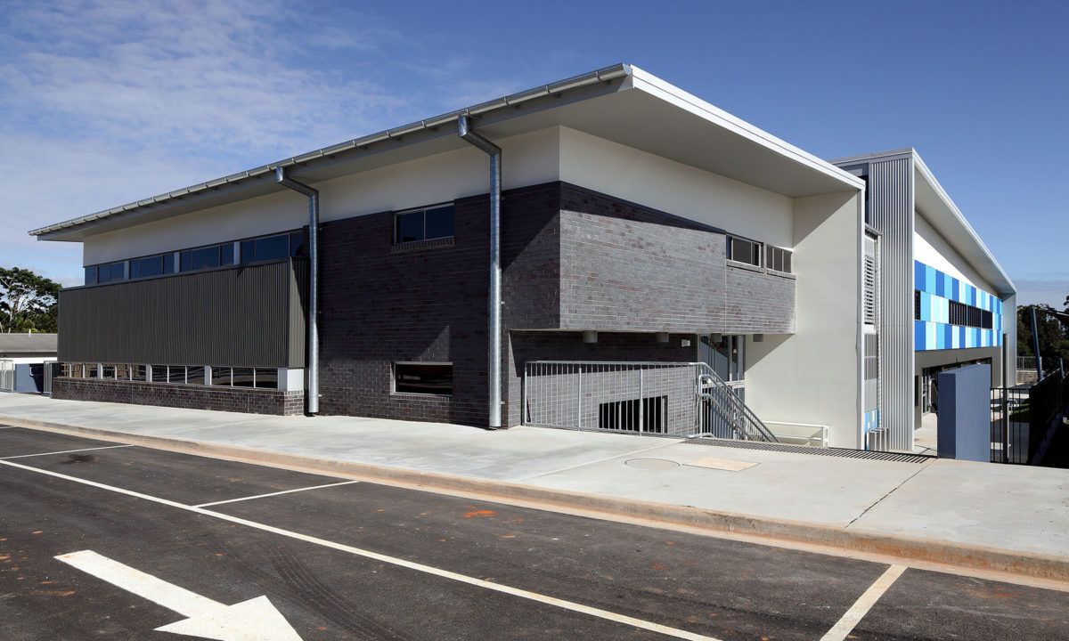 A green and white building with a blue sky in the background