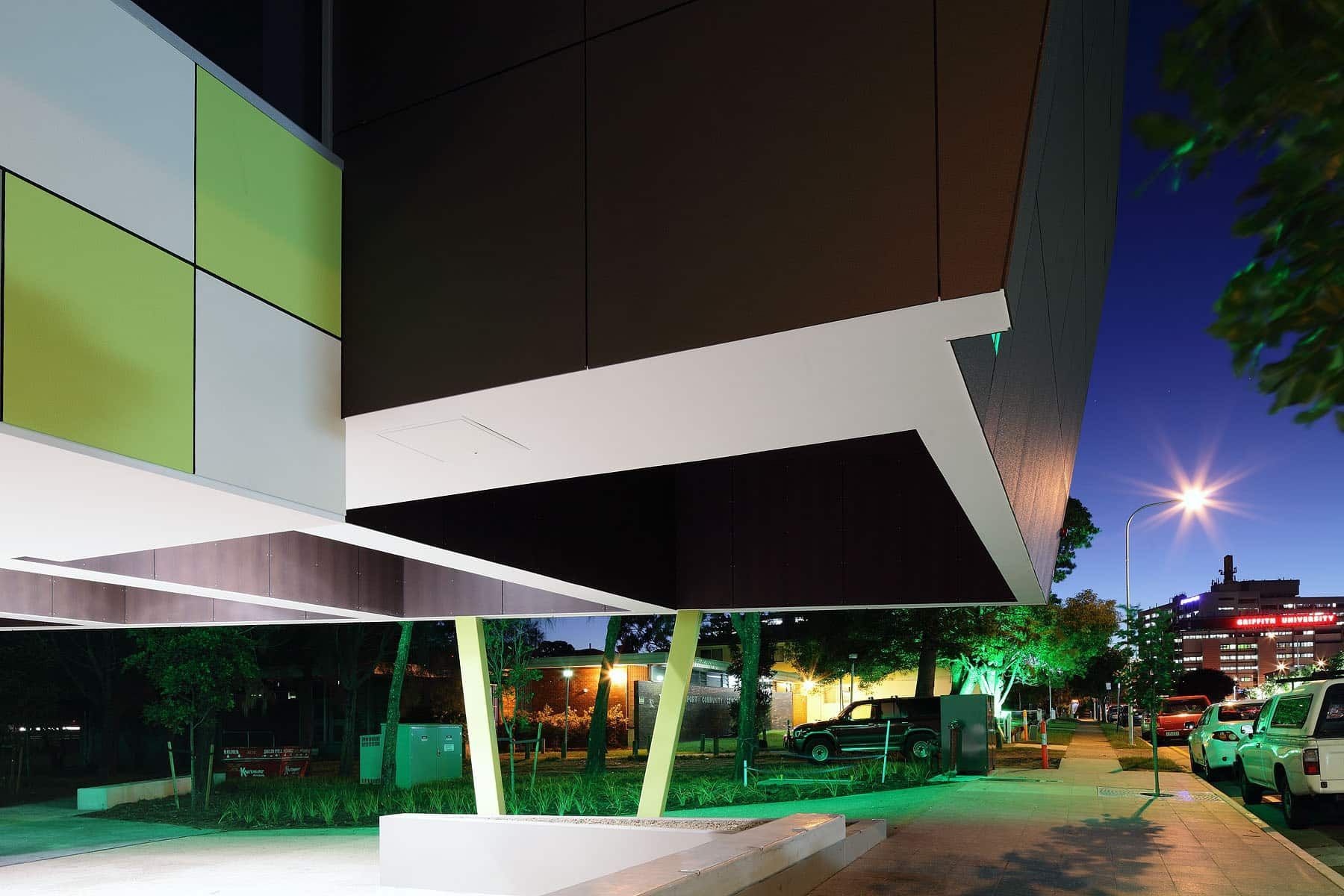 A green and white building with a blue sky in the background