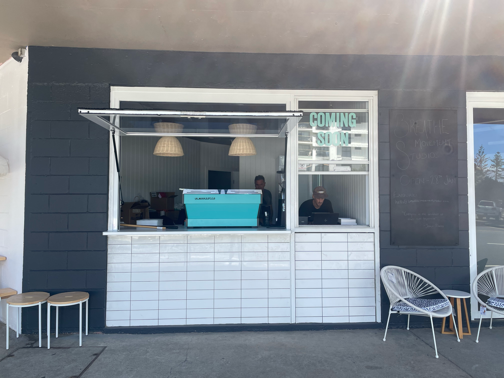 A green and white building with a blue sky in the background