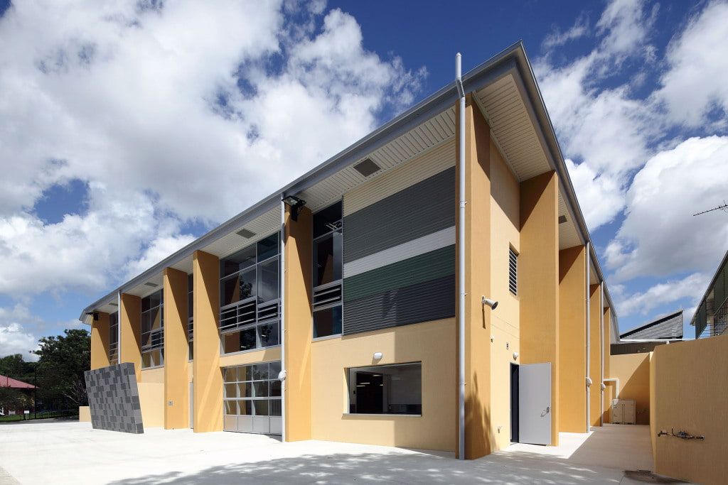 A green and white building with a blue sky in the background