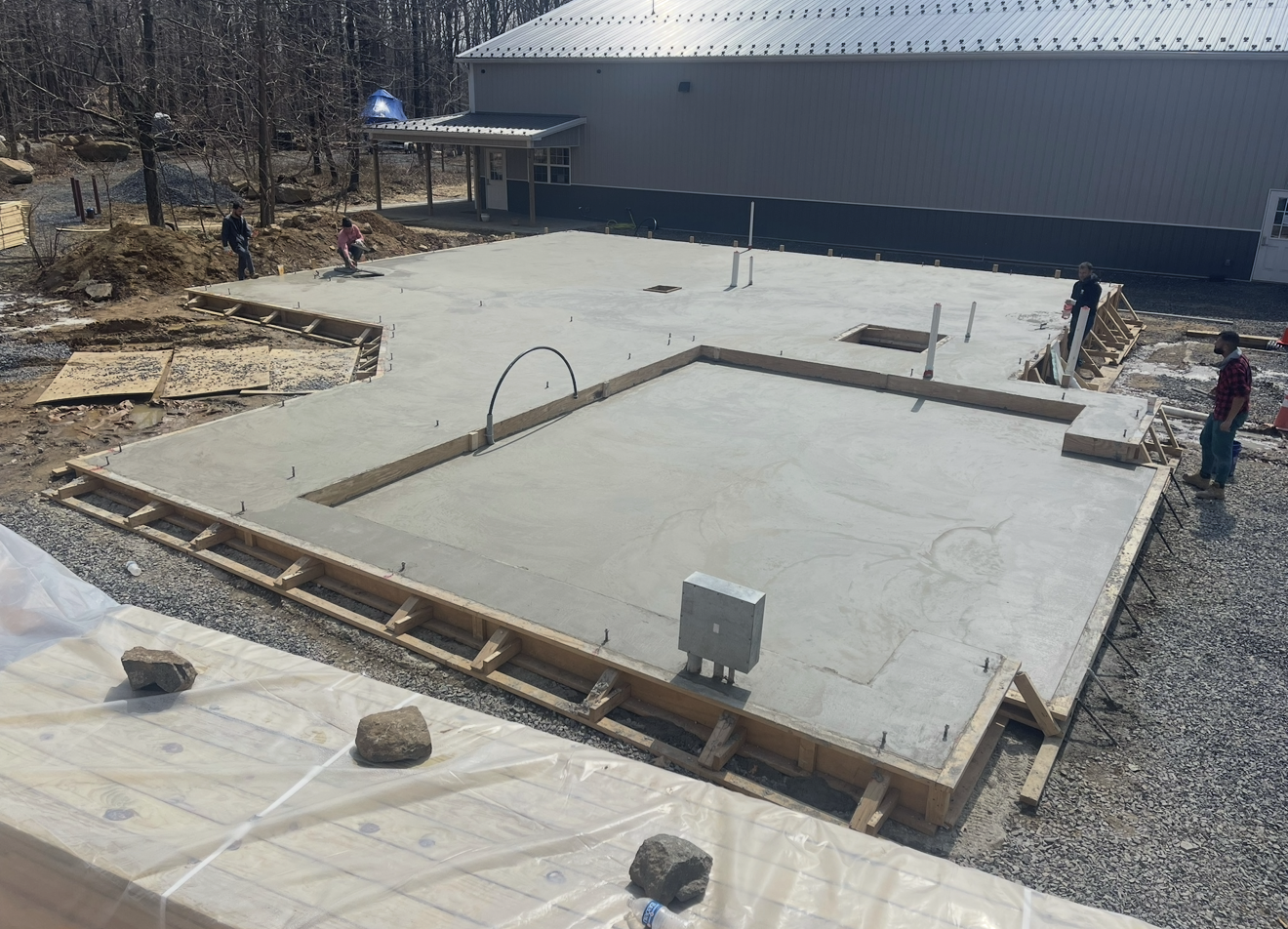 A concrete floor is being built in front of a building.