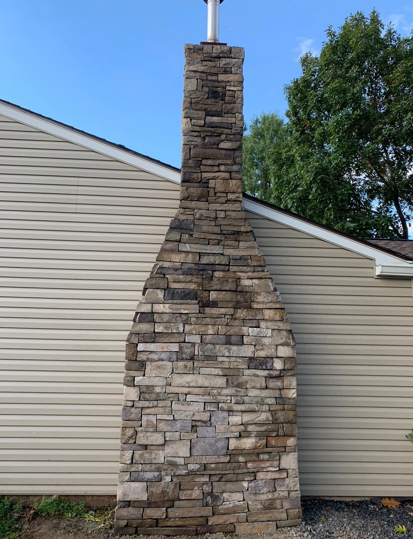 A concrete walkway with a stone wall in the background
