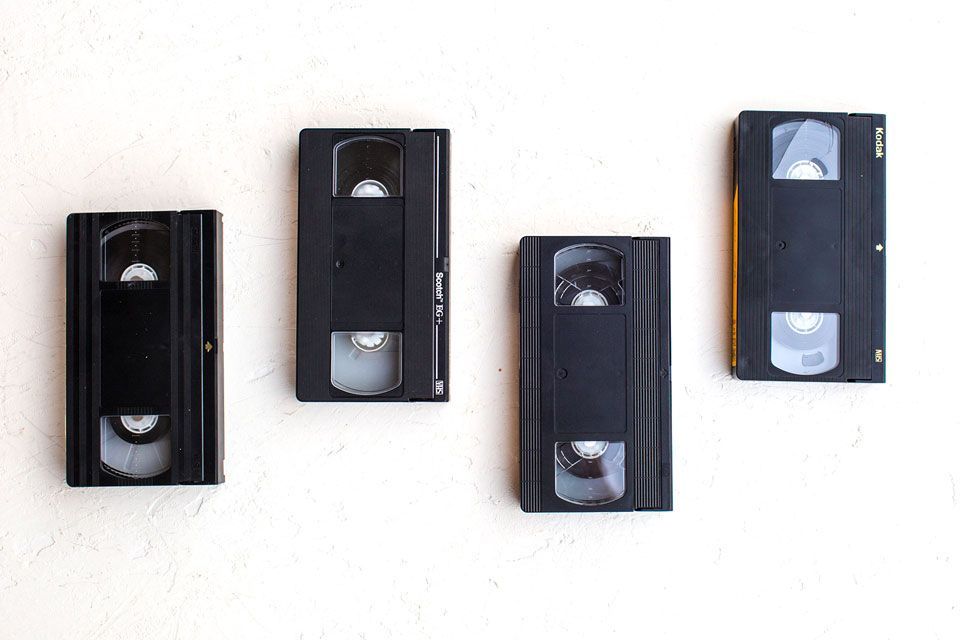 Four VHS tapes sitting on a white table