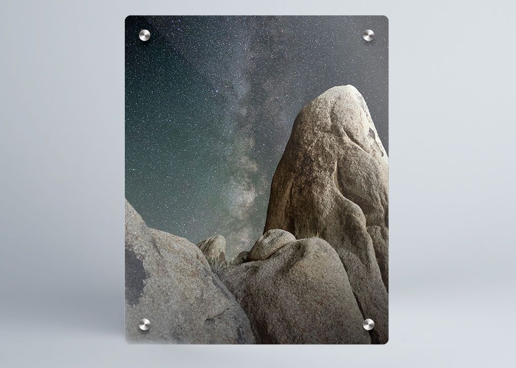 A sample showing the front of a metal print with stand-off mounts featuring a rock formation at night.