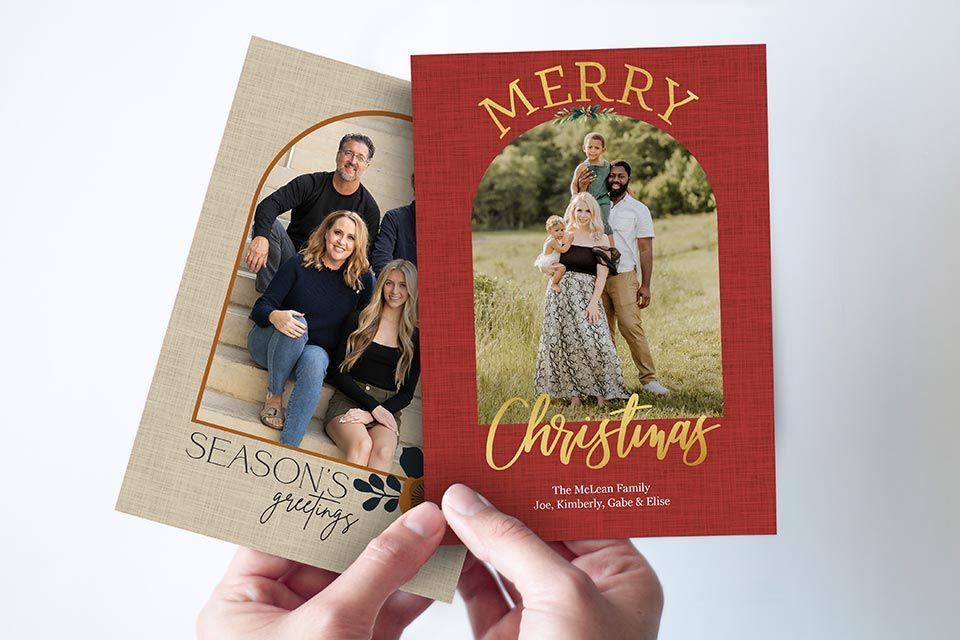 Hands holding two Christmas and holiday cards