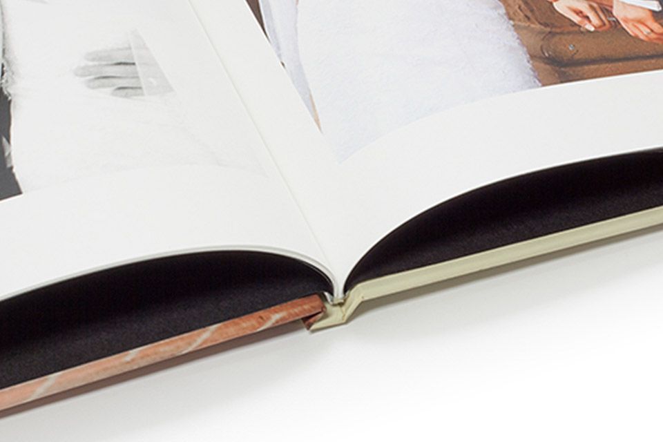 A photo book is open showing the classic binding option. The images in the book look to be of a female.