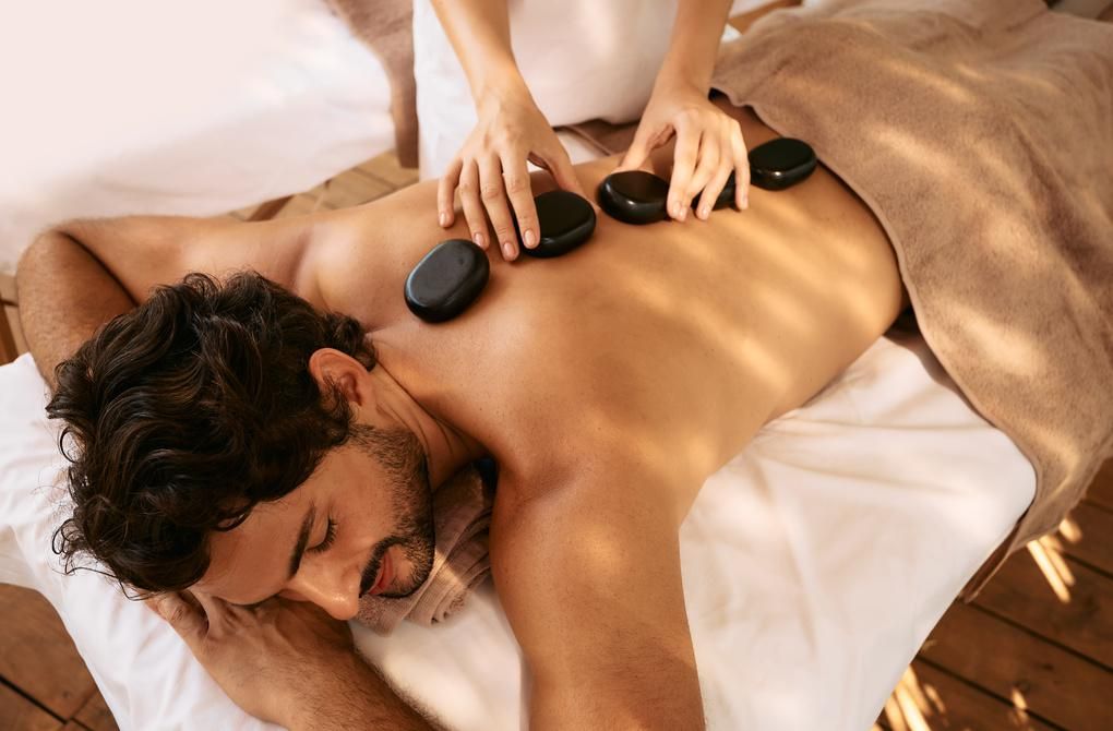 A man is getting a hot stone massage at a spa.