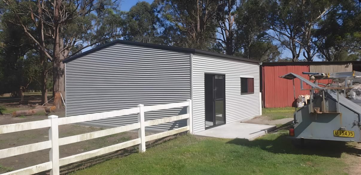 A Shed With a White Fence Around It — Hastings Valley Sheds in Wauchope, NSW