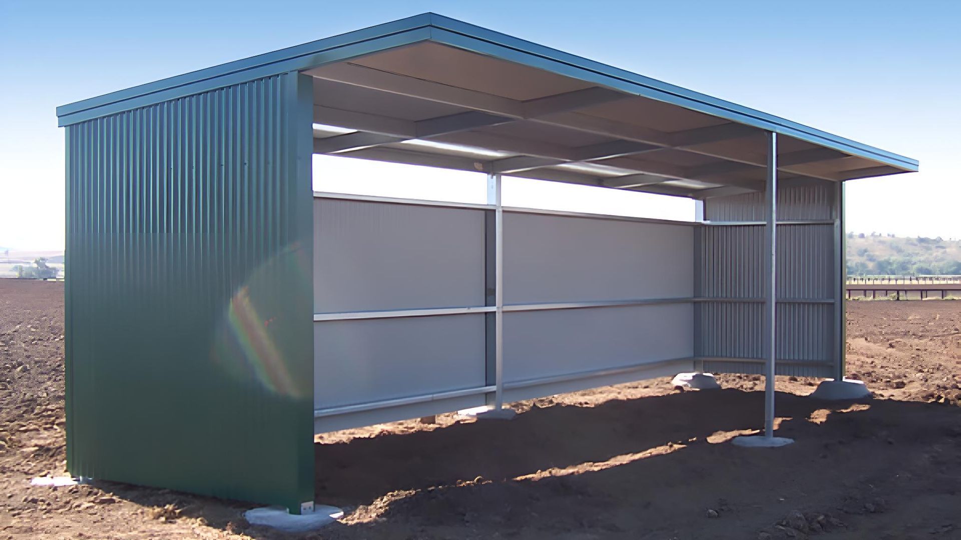 A Green Shed is Sitting in the Middle of a Dirt Field — Hastings Valley Sheds in Wauchope, NSW