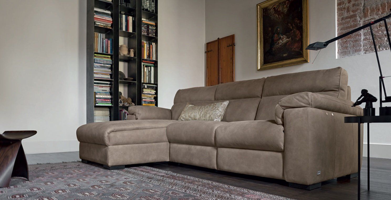 Divano componibile marrone in un soggiorno con libreria e opere d'arte.