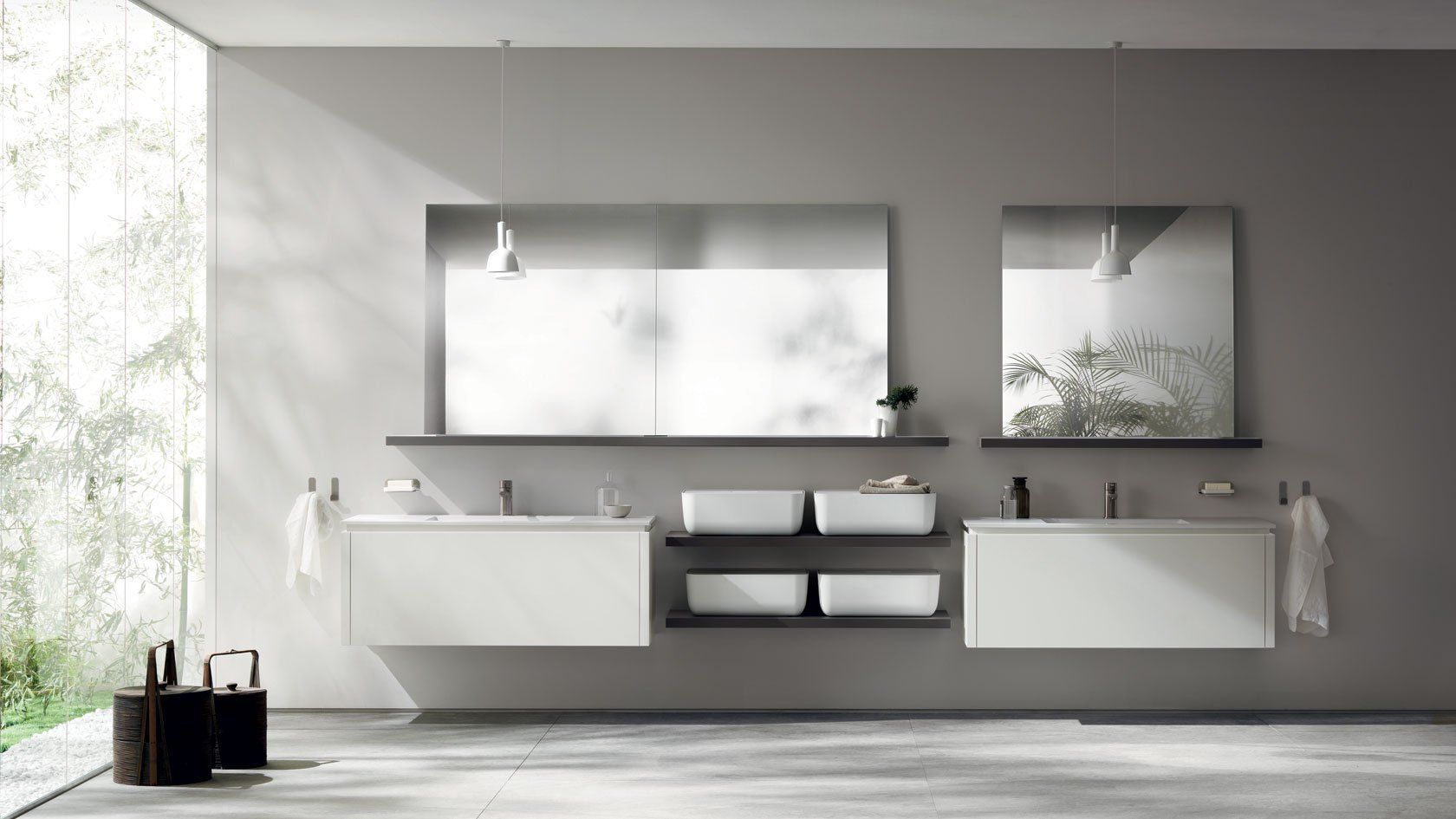 Bagno moderno con pareti grigie, due lavandini bianchi, grandi specchi e vista sul verde.