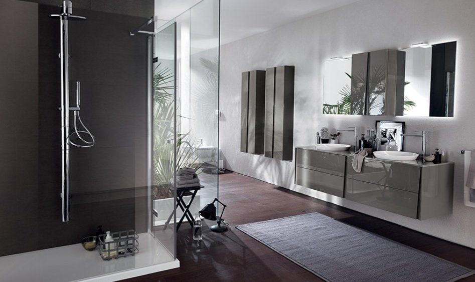 Bagno moderno con doccia, lavabo e grande specchio. Colori grigio e bianco, luce naturale.