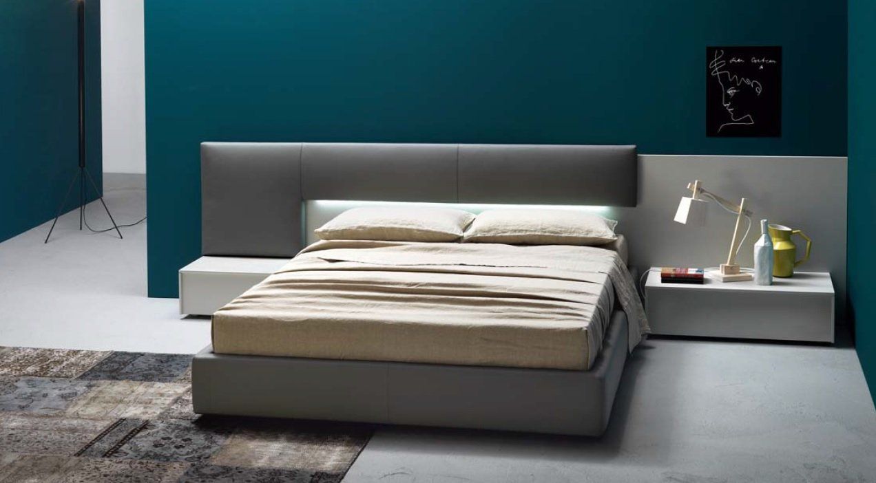 Camera da letto moderna con letto grigio, comodini e parete verde acqua. Il letto è dotato di illuminazione integrata ed è posizionato al centro della stanza.
