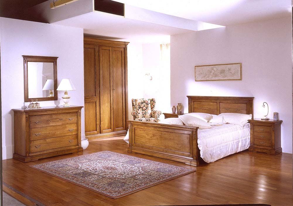 Camera da letto con mobili in legno, letto, cassettiera, armadio e tappeto.