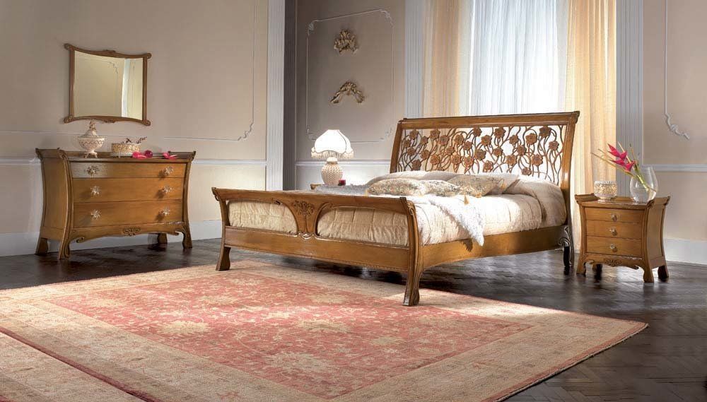 Camera da letto con letto in legno decorato, cassettiera e comodino, tappeto rosa e pareti beige.