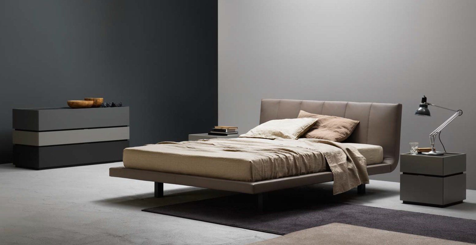 Camera da letto moderna con letto, cassettiera e comodino. Toni del grigio, beige e marrone.