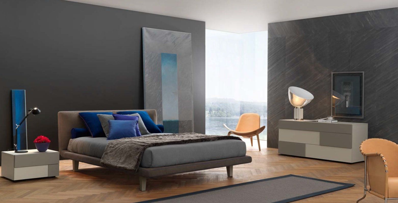 Camera da letto moderna con pareti grigie, letto, cassettiera e due sedie. Arredamento blu e grigio.