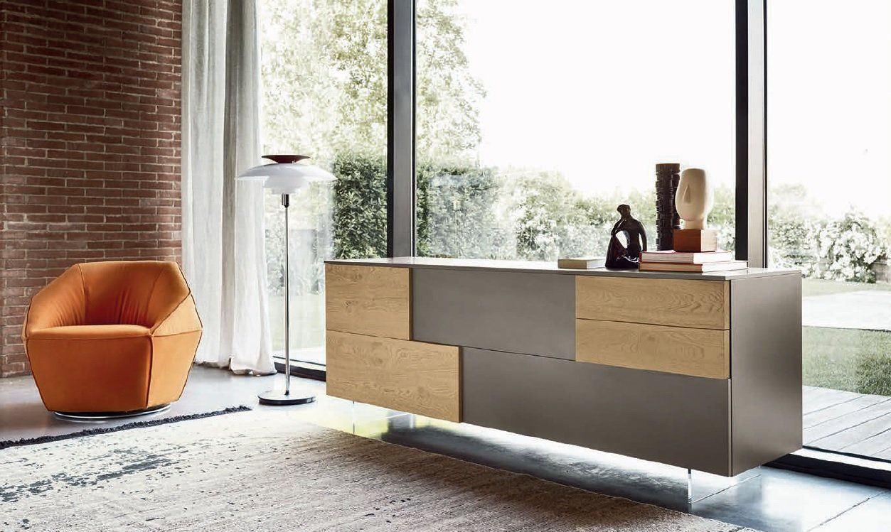 Soggiorno moderno con poltrona arancione, mobile grigio e ampia finestra.