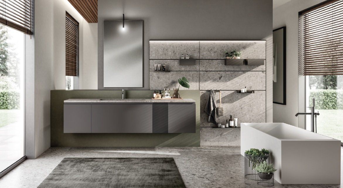 Bagno moderno con mobile lavabo grigio, parete in cemento e vasca da bagno bianca.